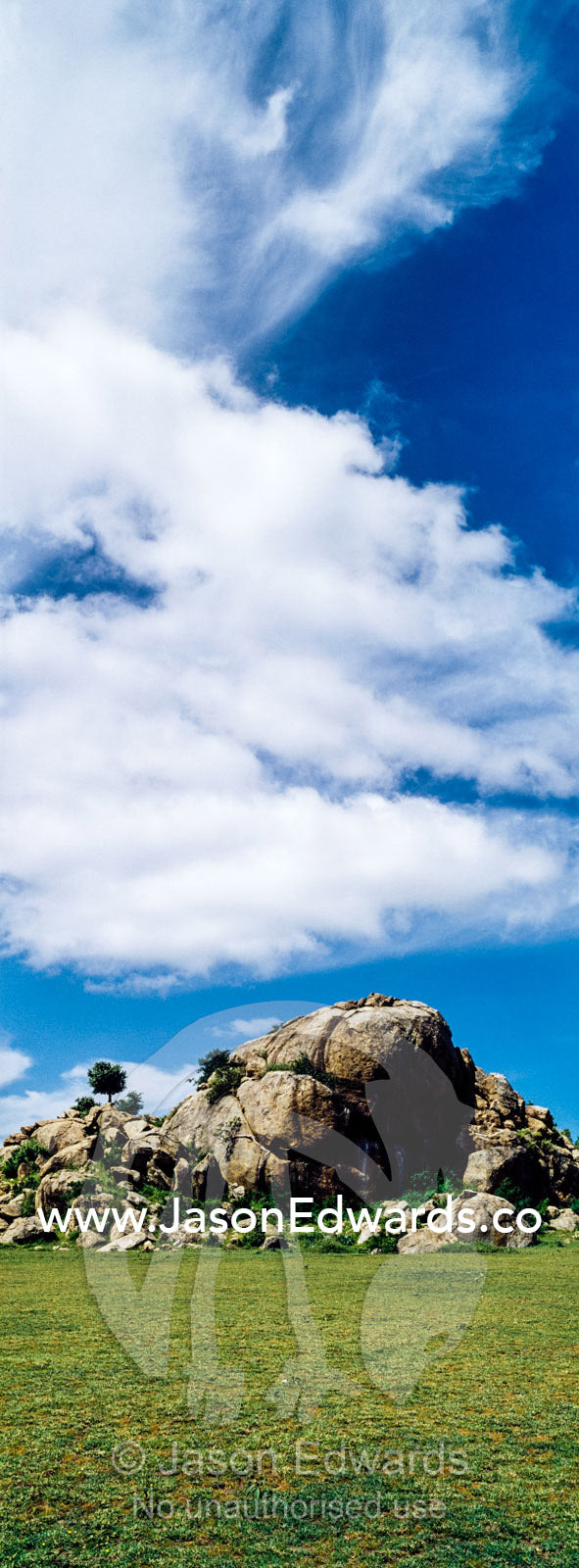 A rocky granite outcrop known as a kopje on a short grass savannah plain. Ngorongoro Conservation Area, Ngorongoro District, Tanzania.