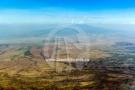 Dry riverbeds and parched plain beneath the slopes of a volcano caldera. Arusha Region, Arusha District, Tanzania.