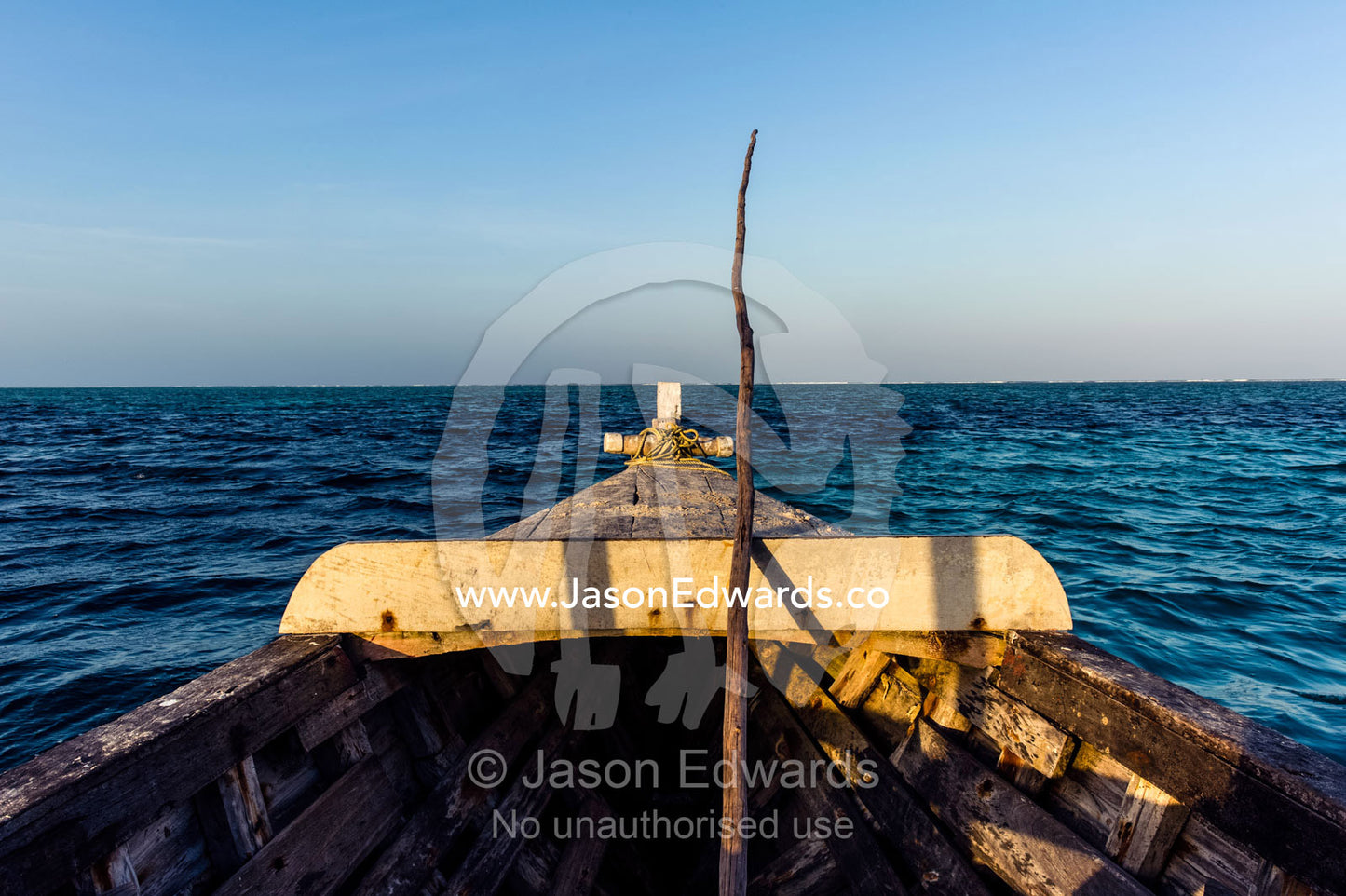 The timber bow of a fishing boat facing out to the Indian Ocean at sunset. Bwejuu, Blue Lagoon Reef, Unguja Island, Zanzibar, Tanzania.