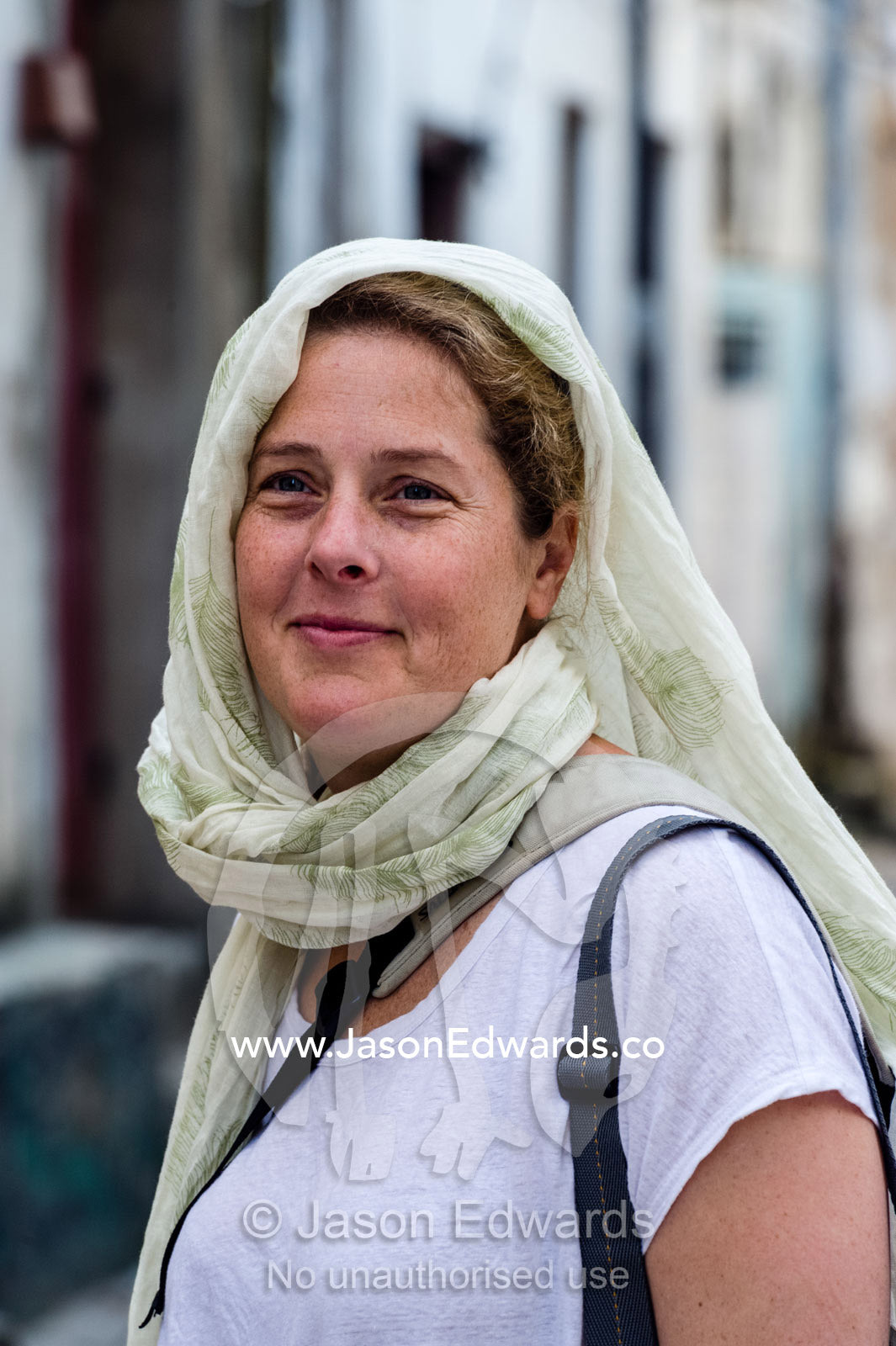 A western tourist wearing a head scarf out of respect for the Muslim culture. Stone Town, Mji Mkongwe, Zanzibar, Unguja Island, Zanzibar, Tanzania.