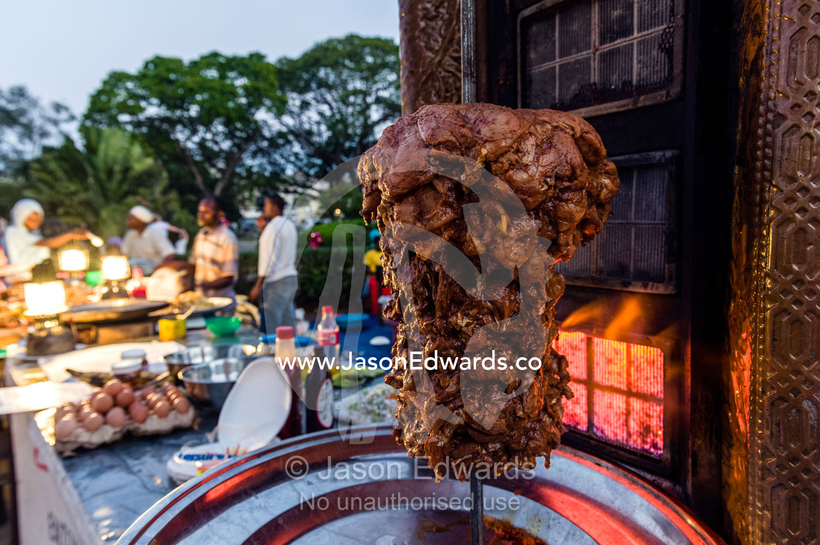 Lamb being flame-grilled for sale in a stall at a night food market. Forodhani Gardens, Stone Town, Mji Mkongwe, Zanzibar, Unguja Island, Zanzibar, Tanzania.