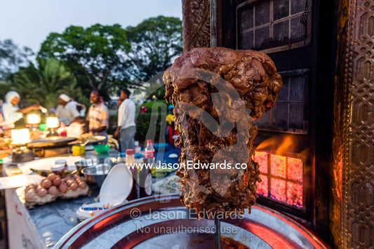 Lamb being flame-grilled for sale in a stall at a night food market. Forodhani Gardens, Stone Town, Mji Mkongwe, Zanzibar, Unguja Island, Zanzibar, Tanzania.