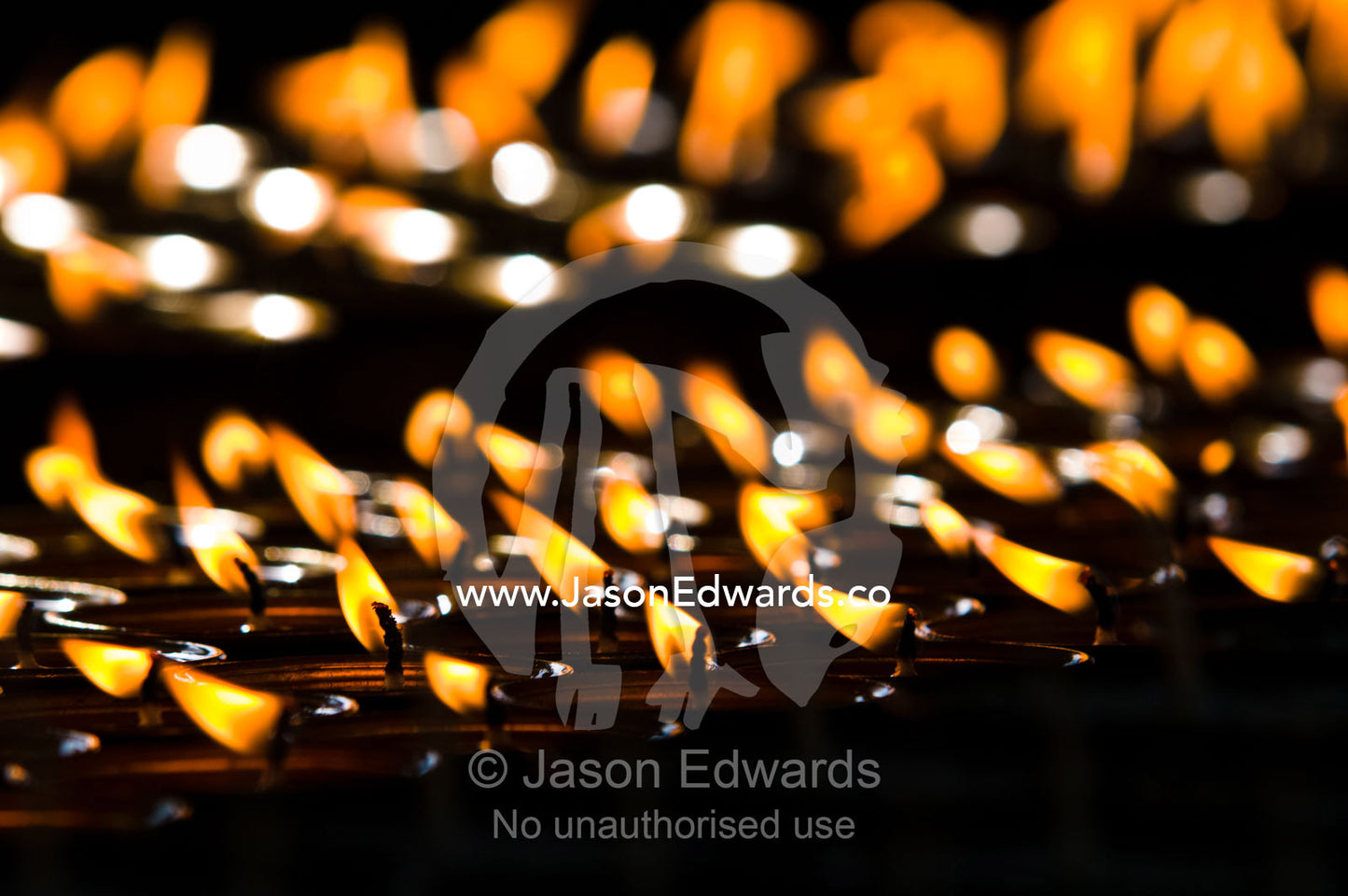 Flames burn in rows of butter lamps for prayers and aspirations at the Thimphu Memorial Chorten. Thimphu Memorial Chorten, Thimphu, Bhutan.