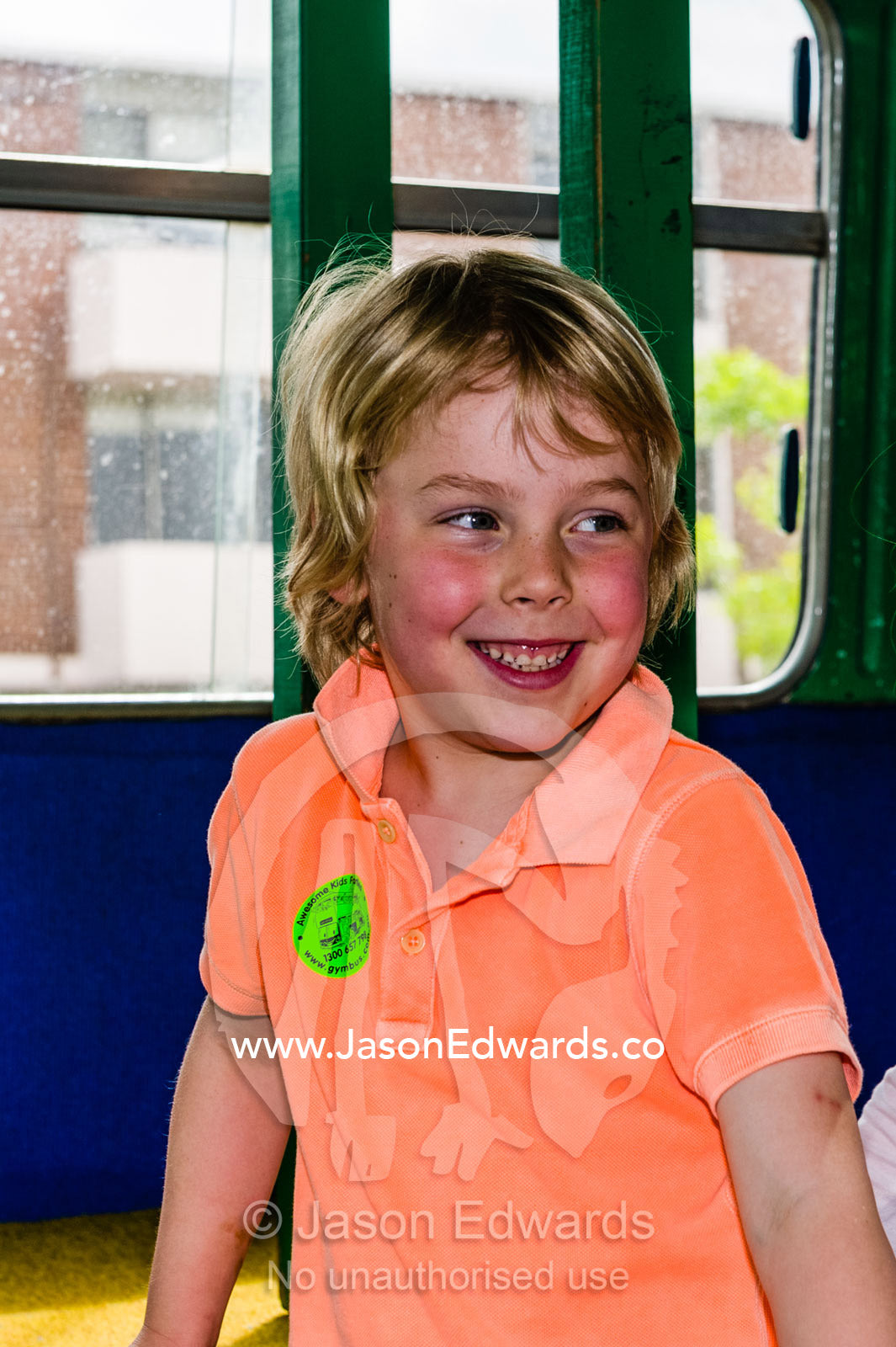 A boy playing on a double-decker bus converted into a birthday party venue for gymnastic activities. Carlton North, Melbourne, Victoria, Australia.