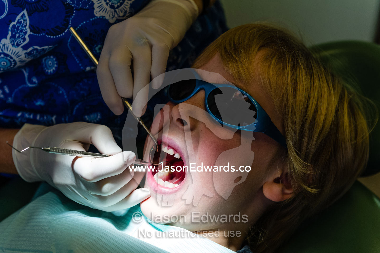 A dentist uses a sickle probe and a mirror to examine a boys teeth. East Melbourne, Melbourne, Victoria, Australia.