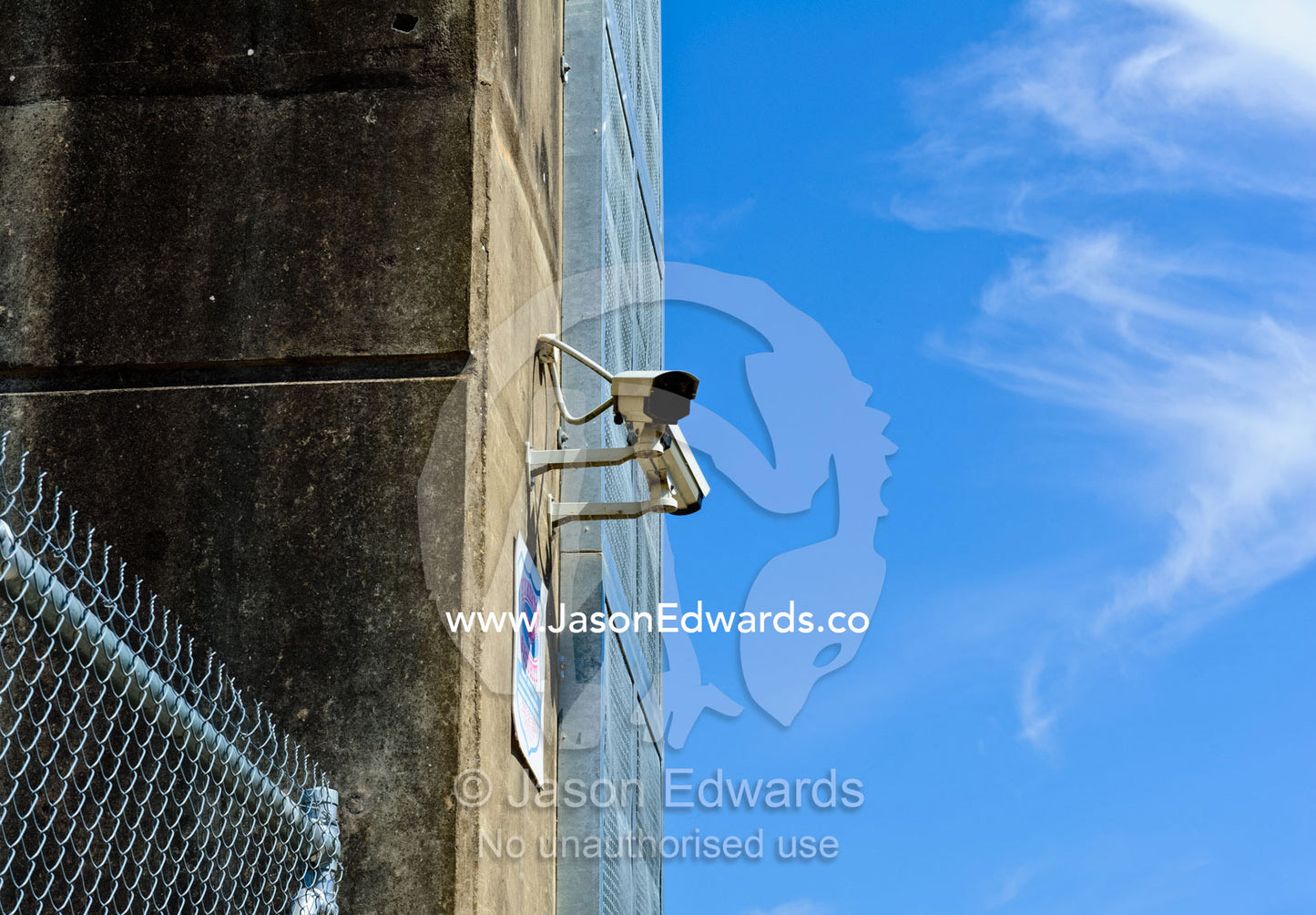 A security camera monitors pedestrian and motor vehicle traffic across a dam wall. Eildon Weir Spillway, Lake Eildon, Victoria, Australia.