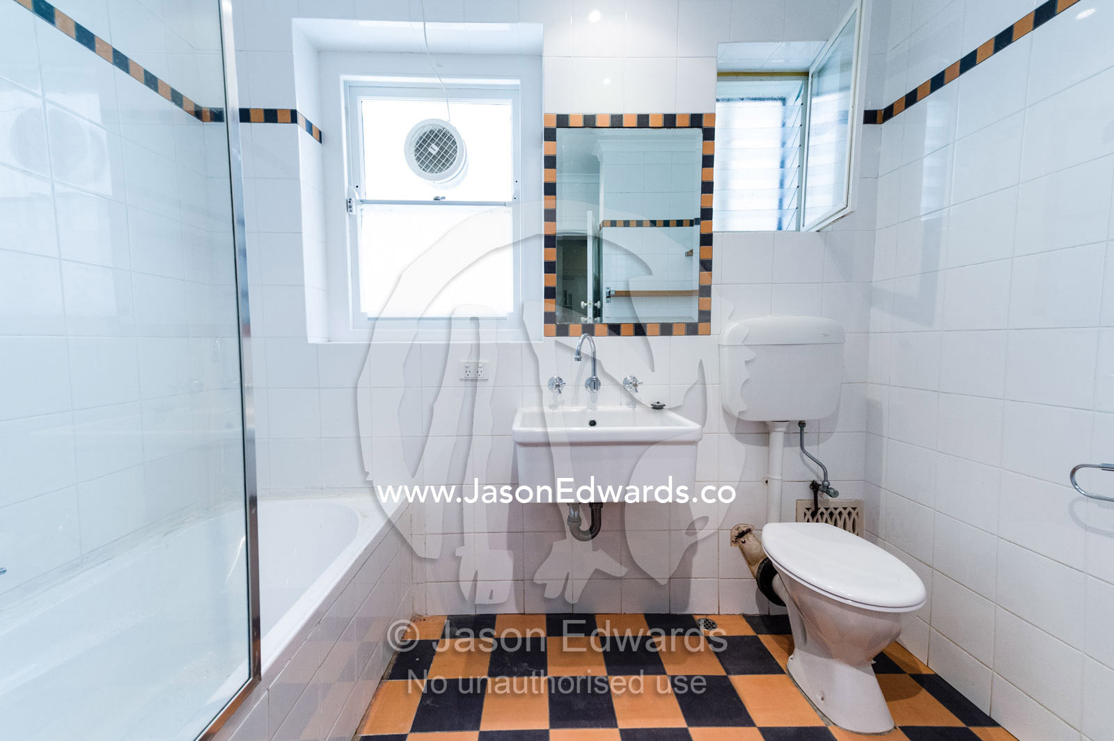 A bathroom and toilet in an empty rental apartment freshly painted and tiled in white. St Kilda Road, Melbourne, Victoria, Australia.