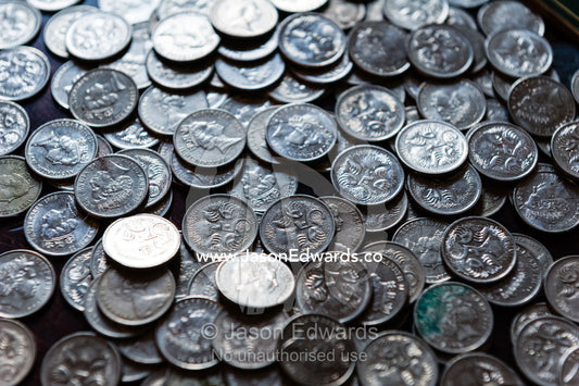 Coins from a child's money-box being sorted into their currency denominations for counting at the bank. Carlton North, Melbourne, Victoria, Australia.