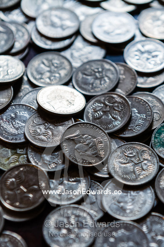 Coins from a child's money-box being sorted into their currency denominations for counting at the bank. Carlton North, Melbourne, Victoria, Australia.