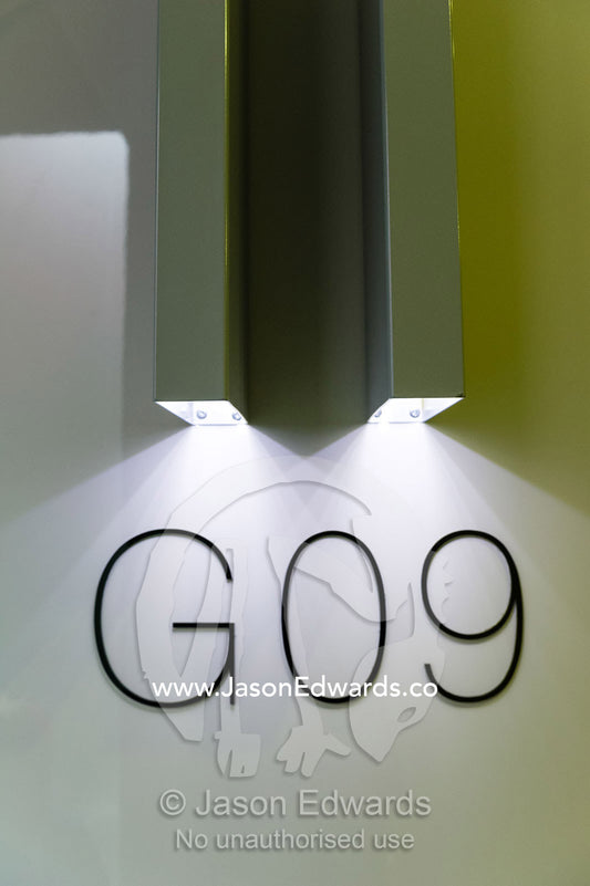 Stainless steel and LED lights illuminate an residence number in an inner-city apartment block. Carlton, Melbourne, Victoria, Australia.
