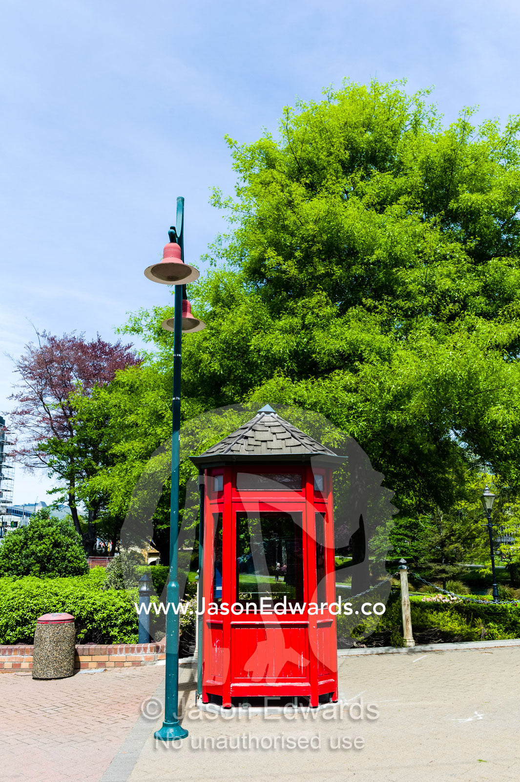 An antique bright red English telephone box and streetlight. Christchurch, South Island, New Zealand.