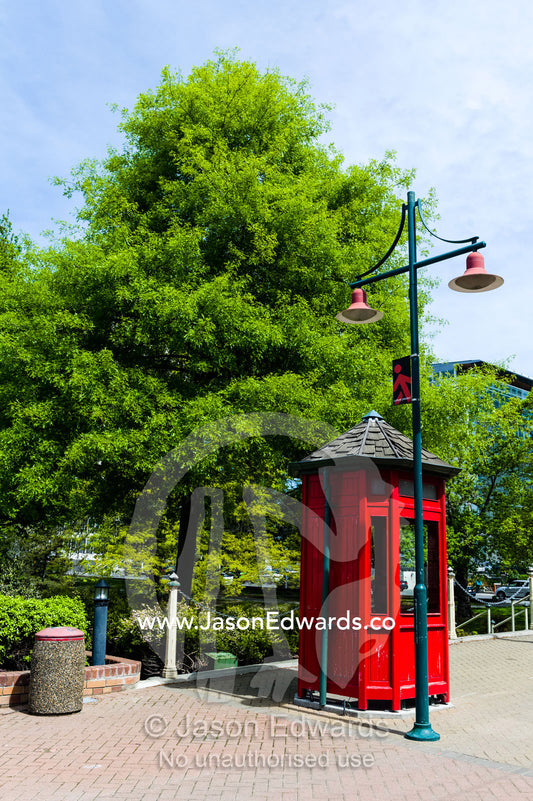 An antique bright red English telephone box and streetlight Christchurch, South Island, New Zealand