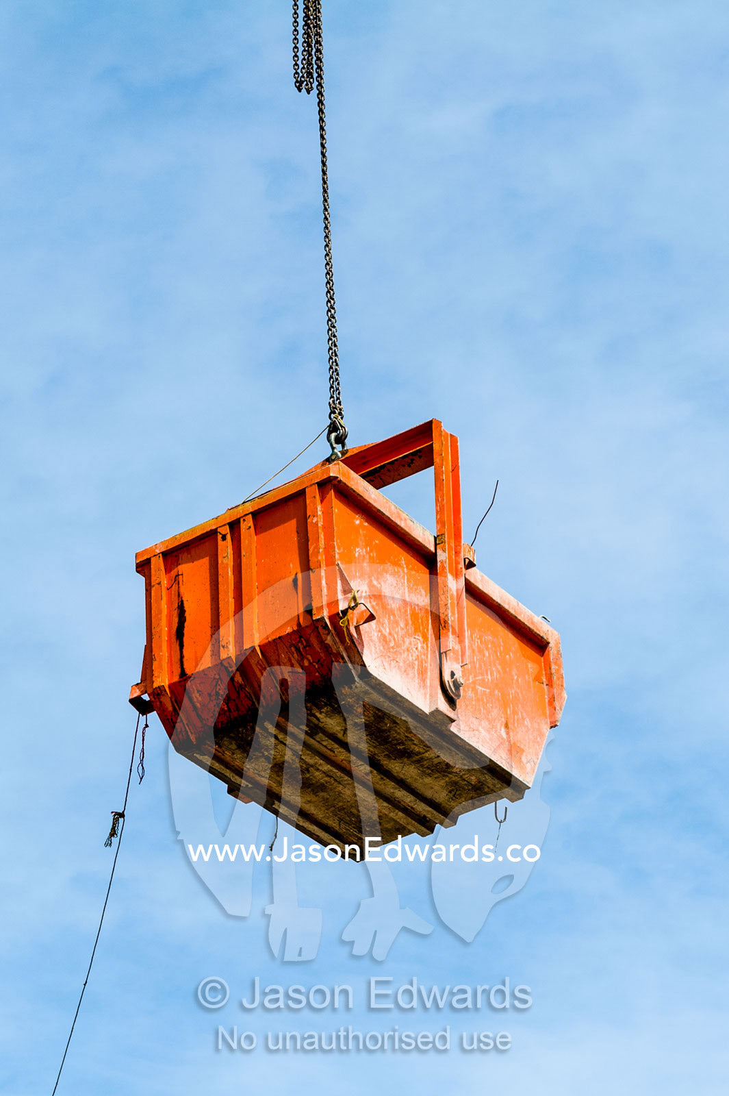 A crane lifts a steel bucket removing rubble from a building destroyed in an earthquake. Christchurch, South Island, New Zealand.