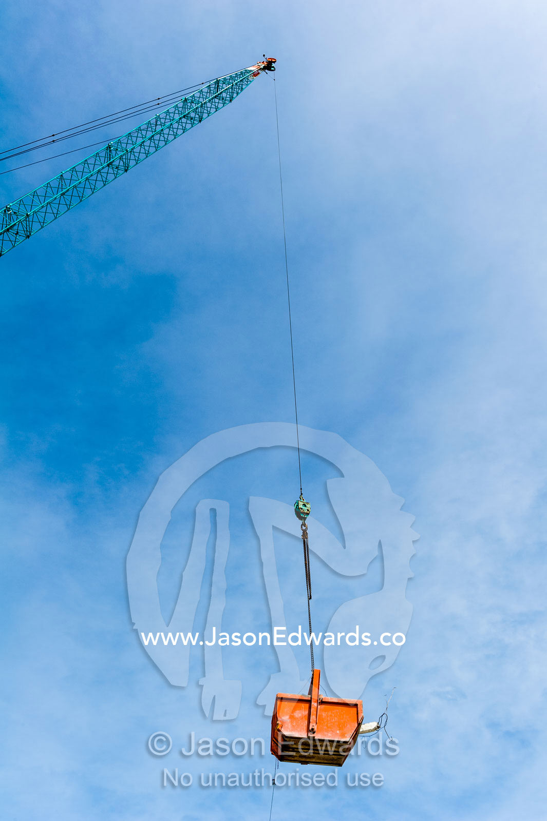 A crane lifts a steel bucket removing rubble from a building destroyed in an earthquake. Christchurch, South Island, New Zealand.