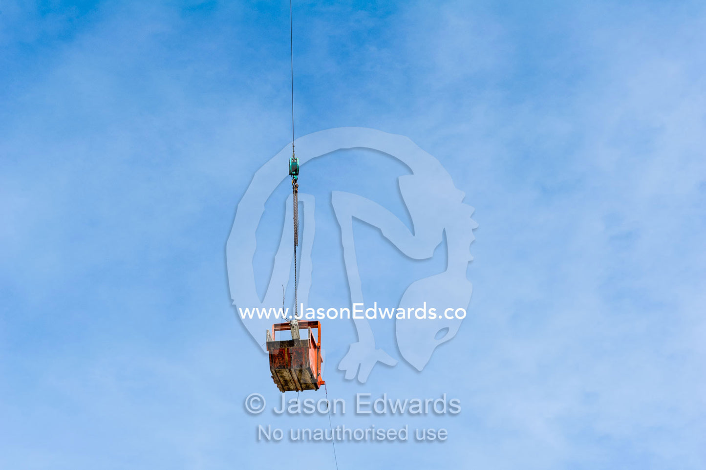 A crane lifts a steel bucket removing rubble from a building destroyed in an earthquake. Christchurch, South Island, New Zealand.