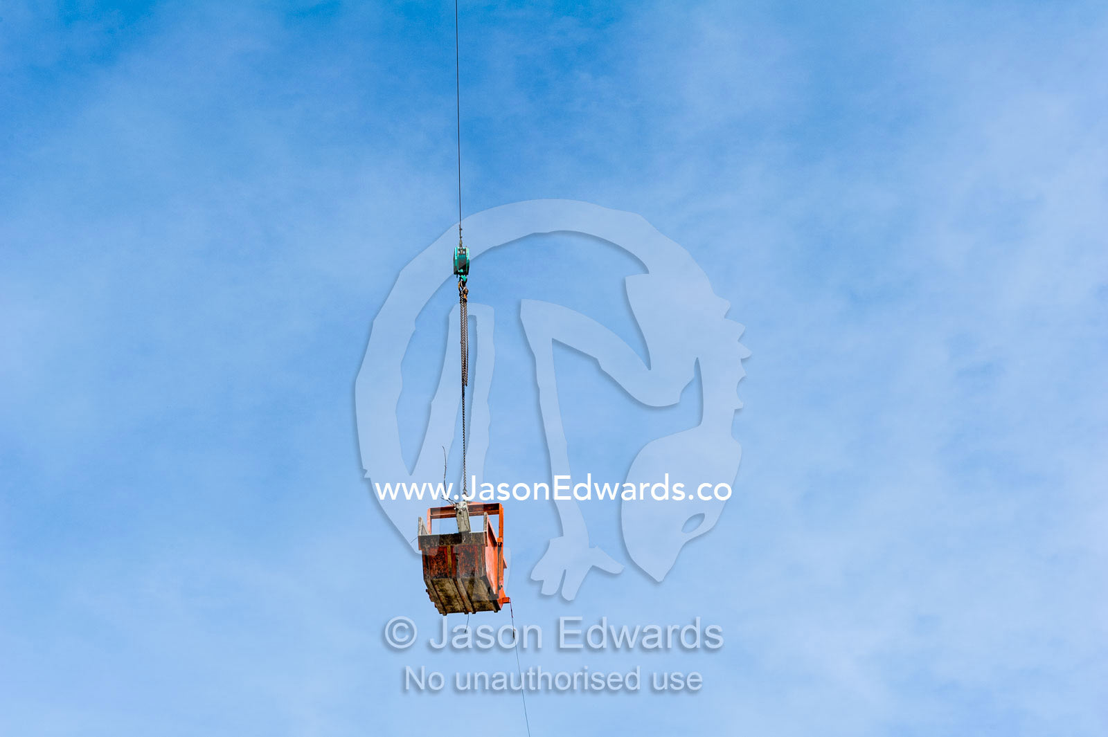 A crane lifts a steel bucket removing rubble from a building destroyed in an earthquake. Christchurch, South Island, New Zealand.
