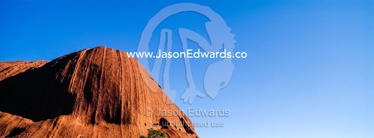 A sandstone dome on Uluru points into a clear blue desert sky. Uluru Kata Tjuta National Park, Northern Territory, Australia.