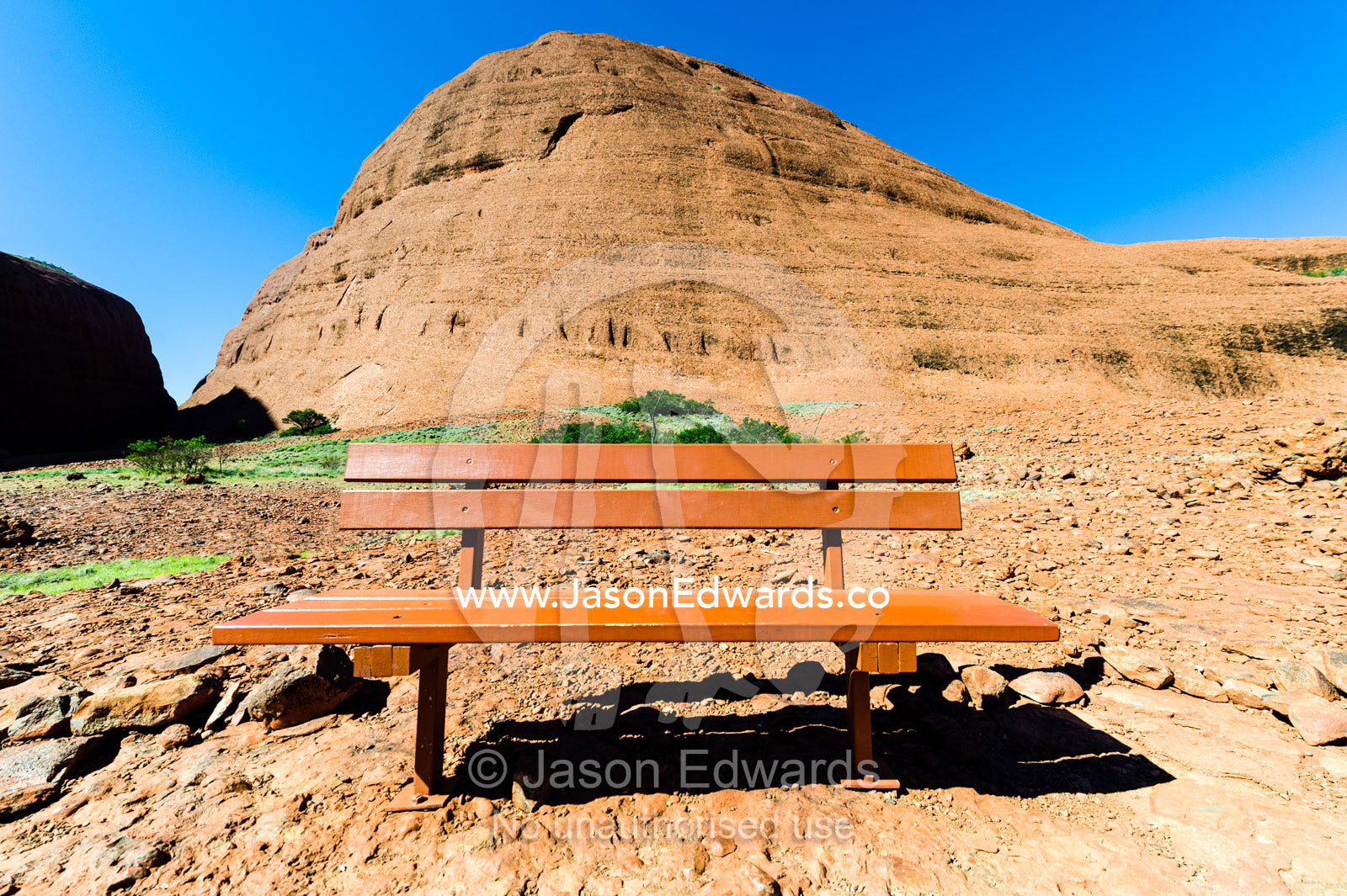 A bench seat at the base of a Kata Tjuta dome for hikers to rest from the desert heat. Uluru Kata Tjuta National Park, Northern Territory, Australia.