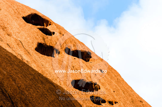 Folds, holes and fissures caused by water and wind erosion in the sandstone surface of Uluru. Uluru Kata Tjuta National Park, Northern Territory, Australia.