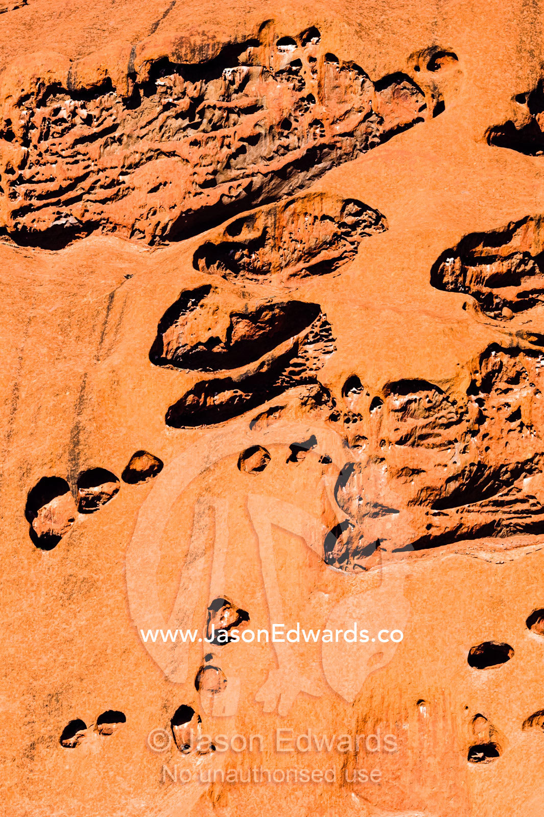 Folds, holes and fissures caused by water and wind erosion in the sandstone surface of Uluru. Uluru Kata Tjuta National Park, Northern Territory, Australia.