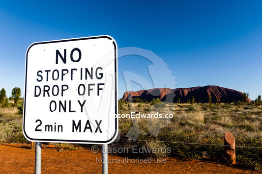 A sign prevents tourists from stopping along the road to view Uluru. Uluru Kata Tjuta National Park, Northern Territory, Australia.