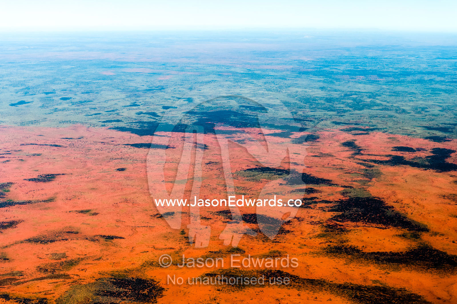 A mosaic of sand dunes and desert plants on a remote plain in Australia's arid outback. Uluru Kata Tjuta National Park, Northern Territory, Australia.