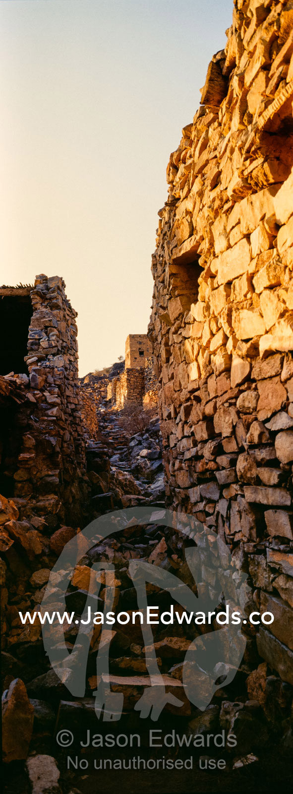 Ancient handmade stone buildings, shops and homes line a street in an abandoned village. Wadi Nakhar, Al Hamra, Ad Dakhiliyah Region, Sultanate of Oman.