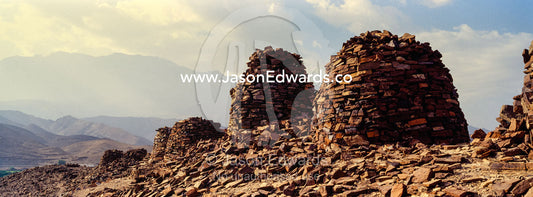 Ancient handmade stone burial mounds and tombs atop a desert ridge. Archaeological Sites of Bat, Al-Ayn, Al Dhahira Region, Sultanate of Oman.