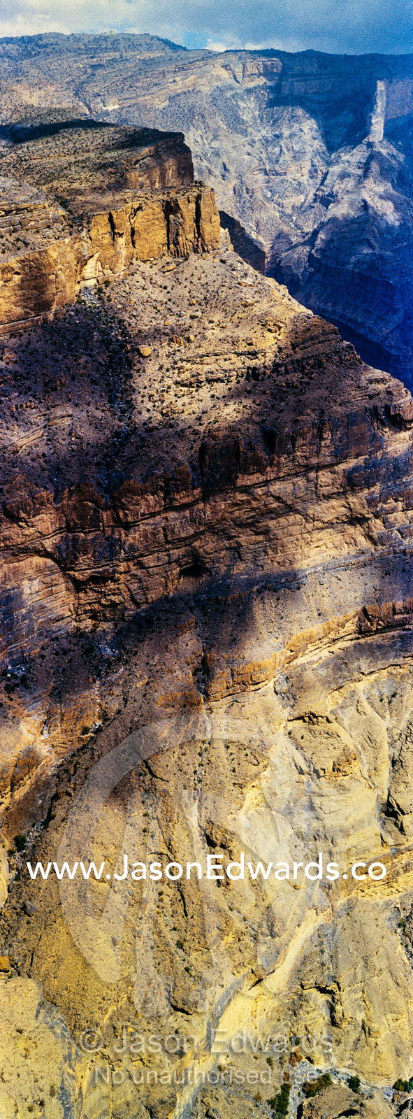 Sheer cliff walls and terraces carved by erosion in a massive desert canyon. Wadi Ghul, Jebel Shams, Al Hajar Mountains, Sultanate of Oman.