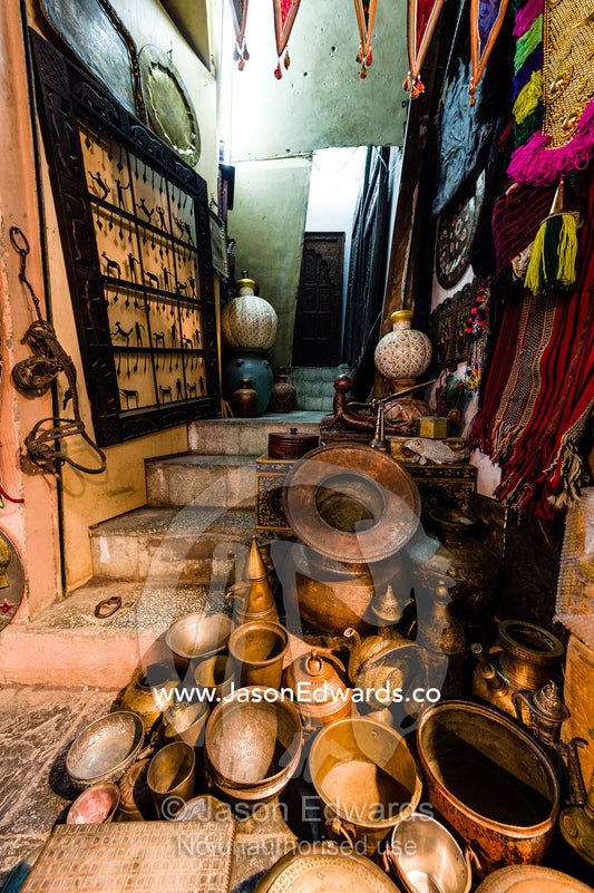 A shop in a market displays and sells varieties of brass pots and bowls for cooking. Mutrah Souq, Muscat, Sultanate of Oman.