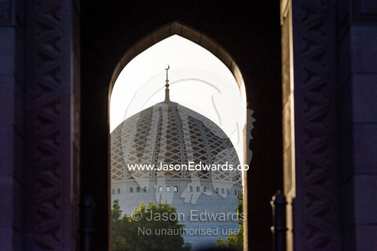The dome of the Prayer Hall on the Grand Mosque viewed through an archway. Sultan Qaboos Grand Mosque, Muscat, Sultanate of Oman.