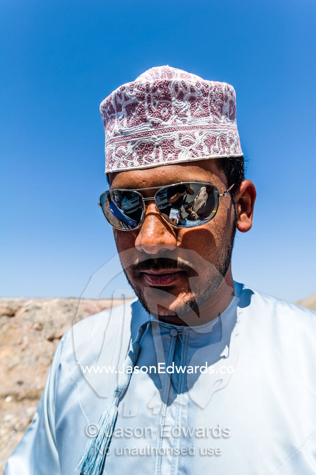 A man from Oman wearing a turban known as a masar, sunglasses and a dishdasha. Muscat, Sultanate of Oman.