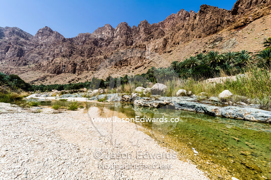 The clear waters of a river flowing through a desert gorge. Mibam, Wadi Tiwi, Sur Al Sharqiyah South Governorate, Sultanate of Oman.
