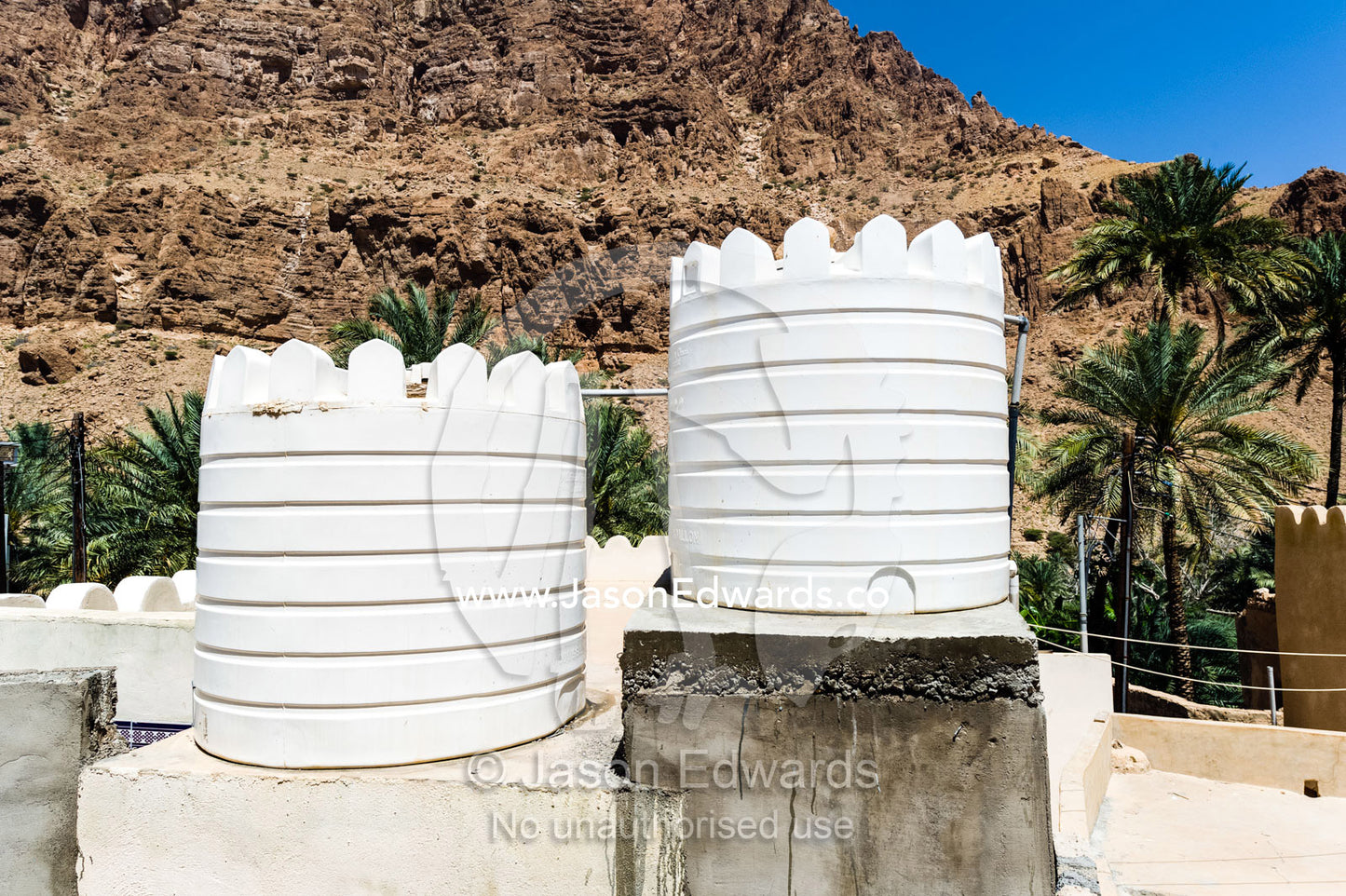 Water tanks on the roof of a house in a desert mountain village. Mibam, Wadi Tiwi, Sur Al Sharqiyah South Governorate, Sultanate of Oman.