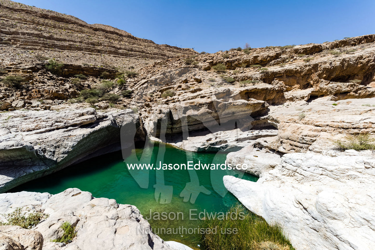 The cool, clear turquoise waters of a wadi in a desert canyon. Wadi Bani Khalid, Sharqiyah Region, Sultanate of Oman.