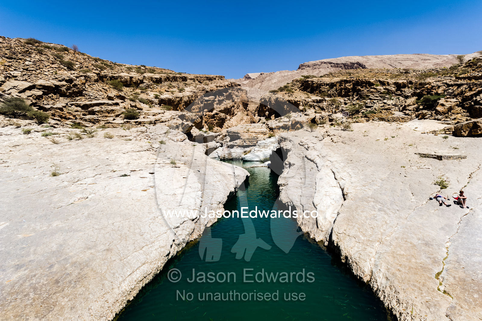 The cool, clear turquoise waters of a wadi in a desert canyon. Wadi Bani Khalid, Sharqiyah Region, Sultanate of Oman.