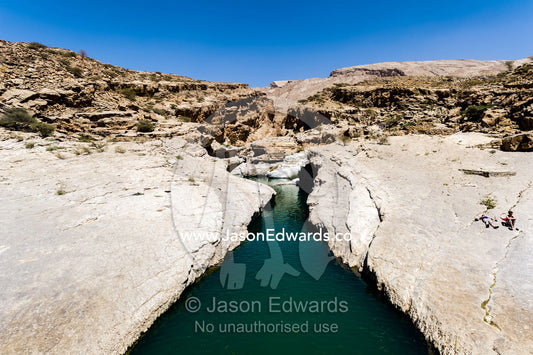 The cool, clear turquoise waters of a wadi in a desert canyon. Wadi Bani Khalid, Sharqiyah Region, Sultanate of Oman.