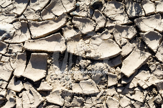 Cracked and baking mud in a dry riverbed in the desert. Wadi Fanja, Dima Wal Taeen, North Al Sharqiyah Governorate, Sultanate of Oman.