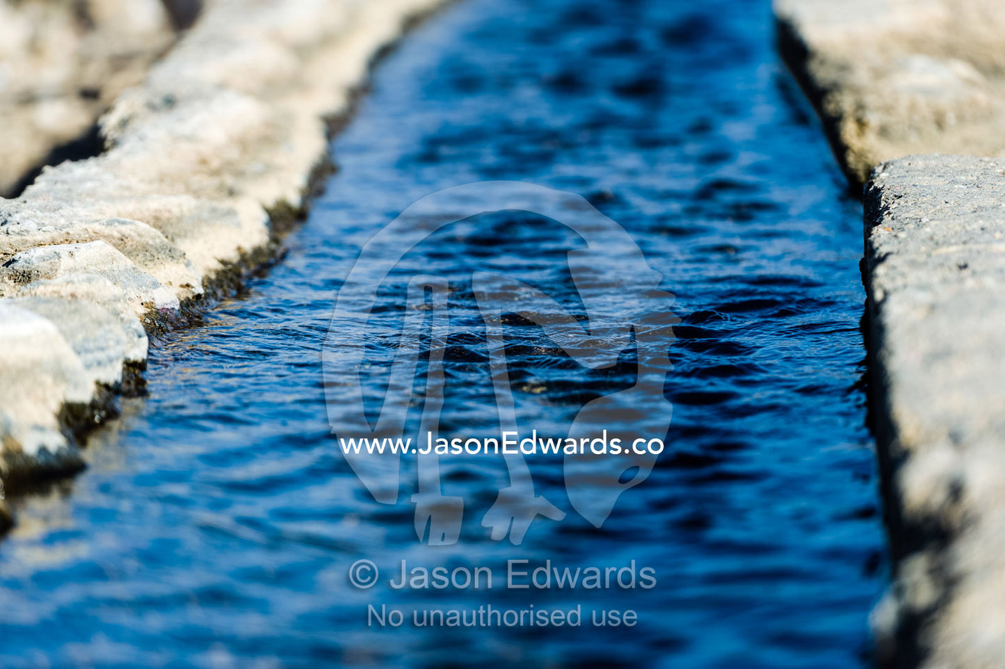 Water runs through a falaj in the desert and is used to irrigate crops and livestock in remote villages. Wadi Fanja, Dima Wal Taeen, North Al Sharqiyah Governorate, Sultanate of Oman.