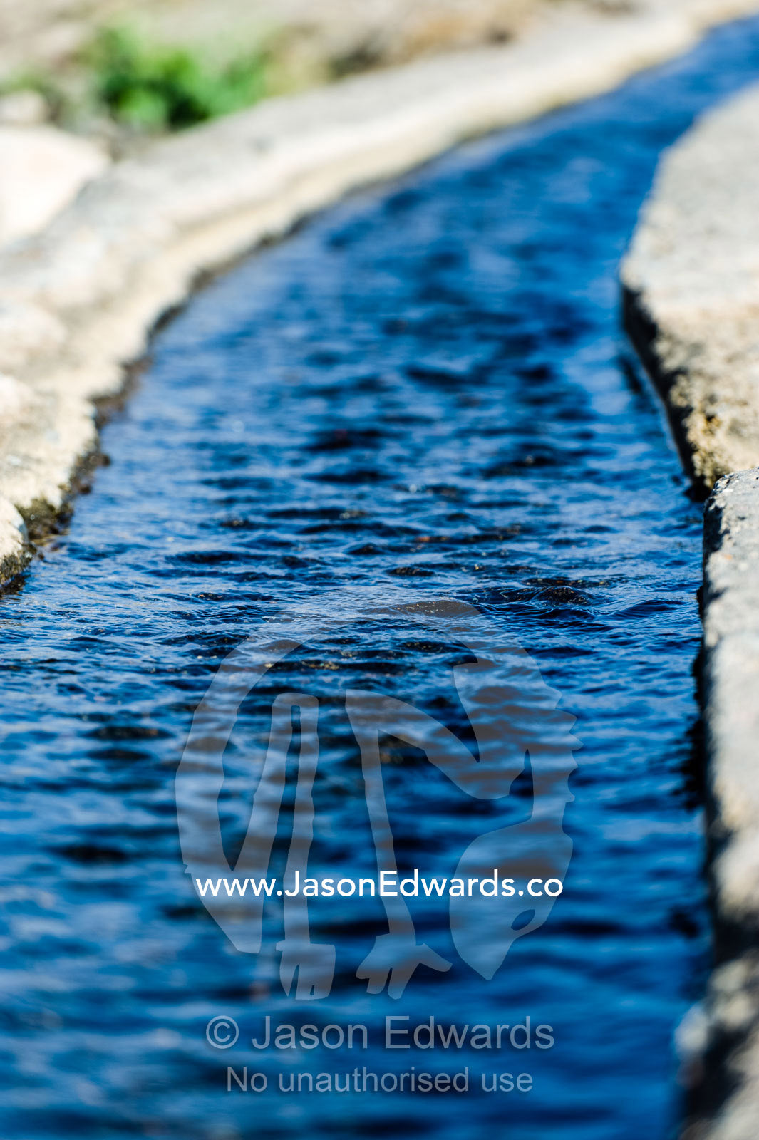 Water runs through a falaj in the desert and is used to irrigate crops and livestock in remote villages. Wadi Fanja, Dima Wal Taeen, North Al Sharqiyah Governorate, Sultanate of Oman.
