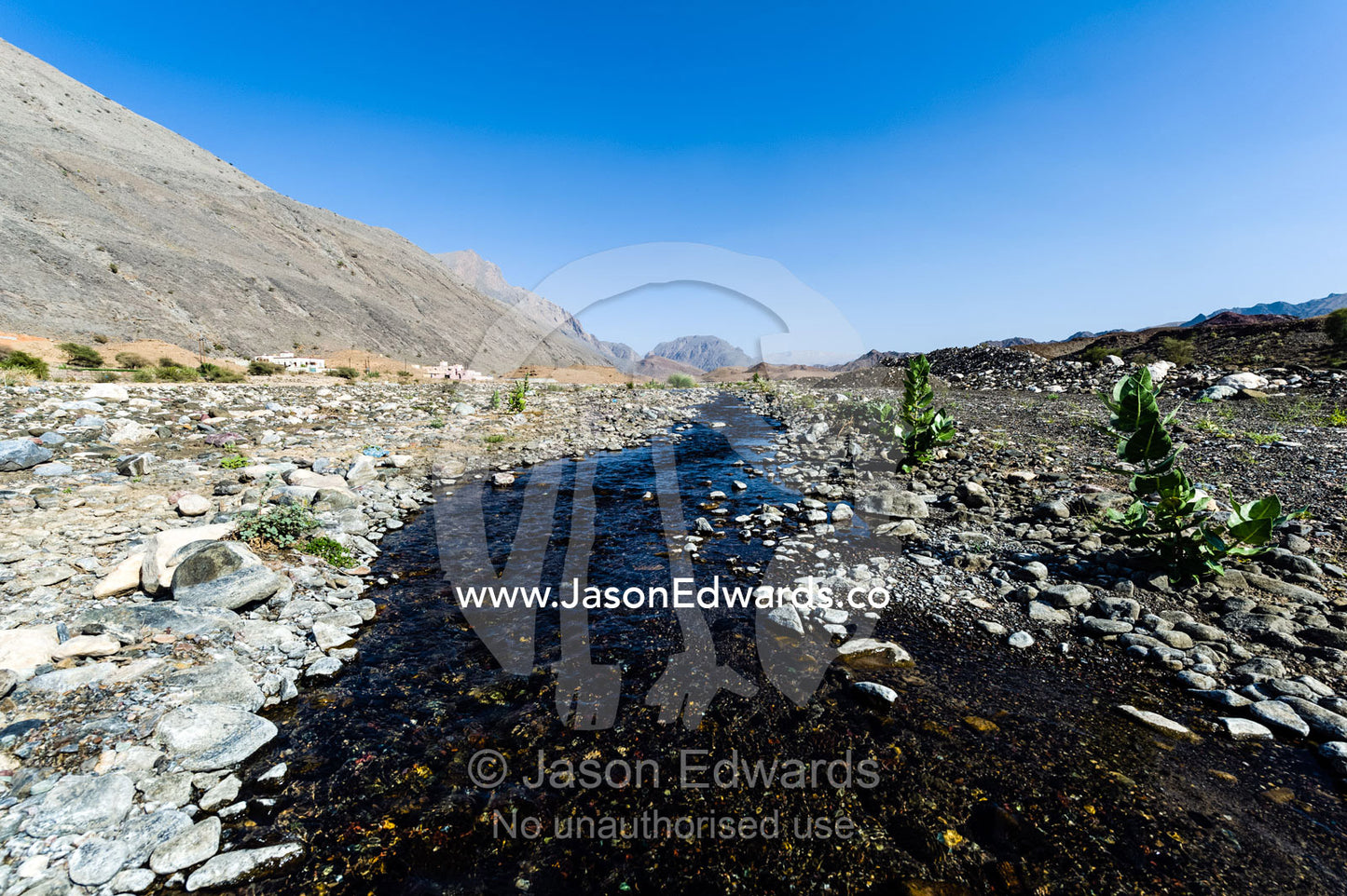 Water runs through a falaj in the desert and is used to irrigate crops and livestock in remote villages. Wadi Fanja, Dima Wal Taeen, North Al Sharqiyah Governorate, Sultanate of Oman.