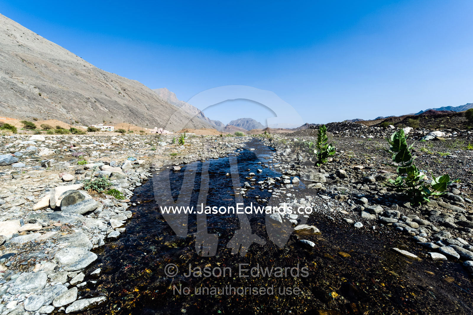Water runs through a falaj in the desert and is used to irrigate crops and livestock in remote villages. Wadi Fanja, Dima Wal Taeen, North Al Sharqiyah Governorate, Sultanate of Oman.