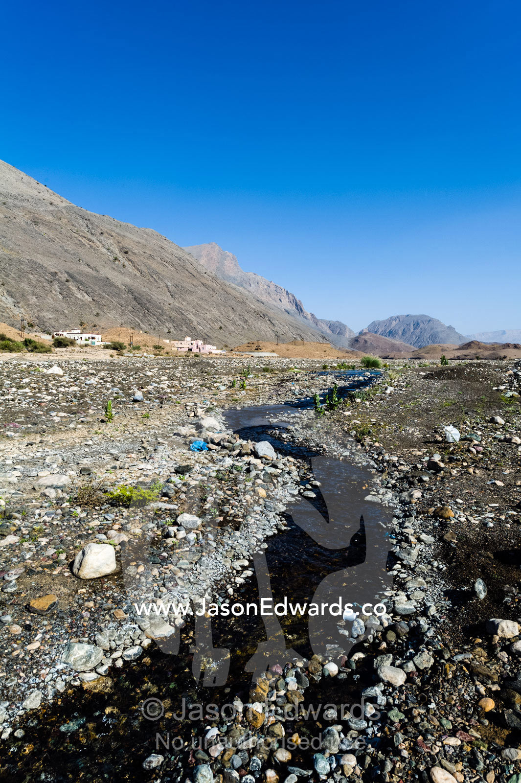 Water runs through a falaj in the desert and is used to irrigate crops and livestock in remote villages. Wadi Fanja, Dima Wal Taeen, North Al Sharqiyah Governorate, Sultanate of Oman.