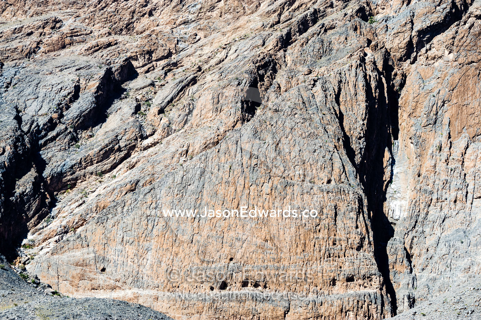 Caves and erosion on the sheer cliff face of a rocky mountain. Adh Dhahir, Dima Wal Taeen, North Al Sharqiyah Governorate, Sultanate of Oman.