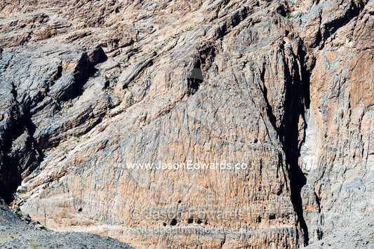 Caves and erosion on the sheer cliff face of a rocky mountain. Adh Dhahir, Dima Wal Taeen, North Al Sharqiyah Governorate, Sultanate of Oman.