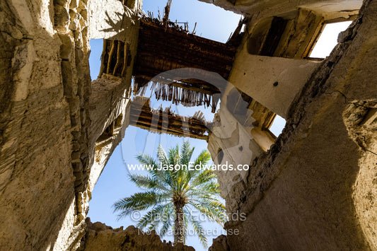 A date palm is visible through the ruin of a merchants home in an ancient village. Ibra, Ash Sharqiyah Region, Sultanate of Oman.