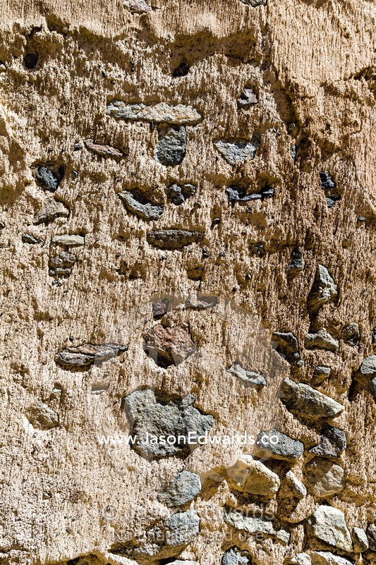 The detail of a sand and stone mud brick wall in an ancient desert village. Ibra, Ash Sharqiyah Region, Sultanate of Oman.