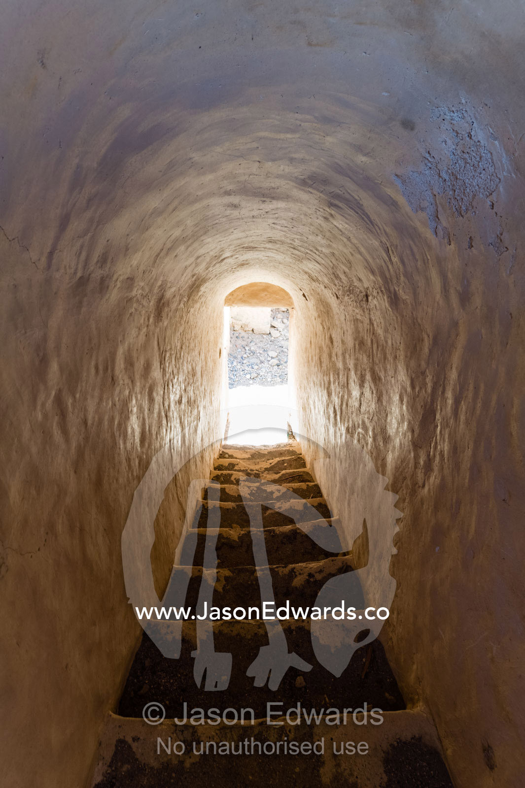 Sunlight reflected off polished stone walls in a village stairwell. Ibra, Ash Sharqiyah Region, Sultanate of Oman.