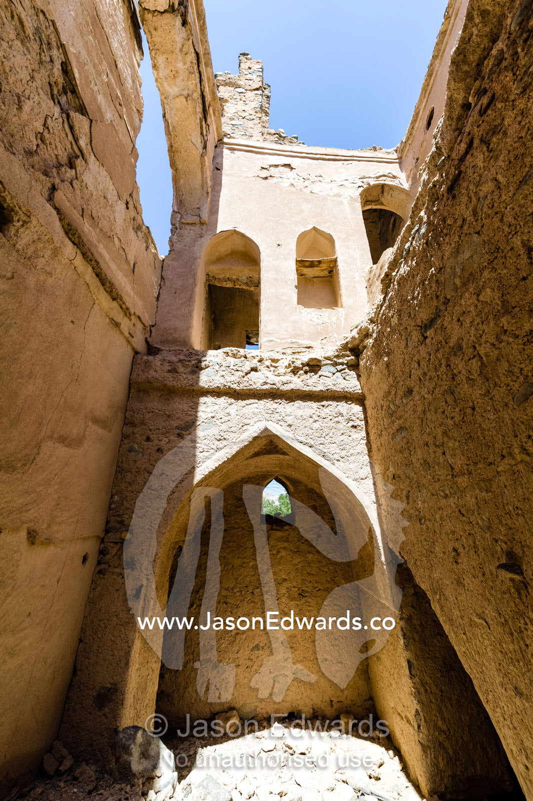 An ornate mud brick archway in a merchant home collapsing in a village in the desert. Ibra, Ash Sharqiyah Region, Sultanate of Oman.