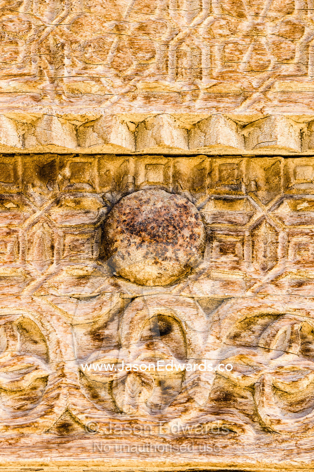Ornate carving in the timber door frame of a home in an ancient desert village. Ibra, Ash Sharqiyah Region, Sultanate of Oman.